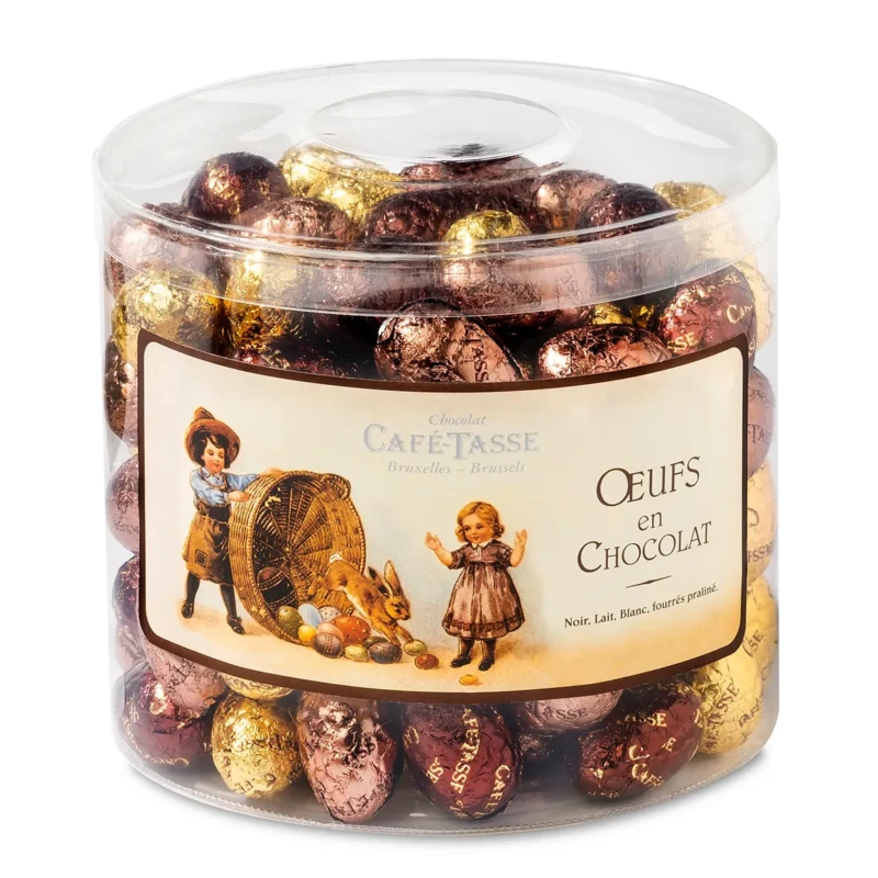 Pot transparent étiqueté « Chocolat Café-Tassé Bruxelles-Brussels, Œufs en Chocolat », illustration vintage d'enfants, rempli d'œufs en chocolat emballés dans des papiers dorés et cuivrés.