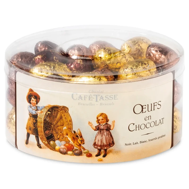 Boîte ronde et large transparente « Chocolat Café-Tassé Bruxelles-Brussels, Œufs en Chocolat », illustration vintage d'enfants et d'un lapin, remplie d'œufs en chocolat dorés et cuivrés.