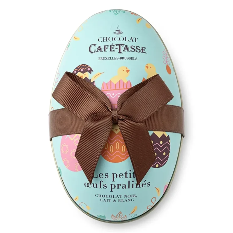 Boîte métallique en forme d'œuf turquoise Café-Tassé, illustrations de poussins de Pâques, nœud en ruban marron, mention « Bruxelles-Brussels ».