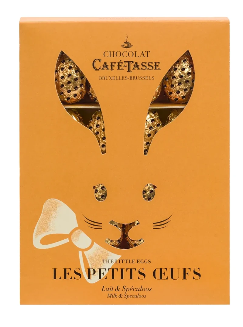Boîte orange Café-Tassé découpée en forme d'oreilles de lapin, laissant apparaître des œufs en chocolat emballés dans un papier alu doré à pois.