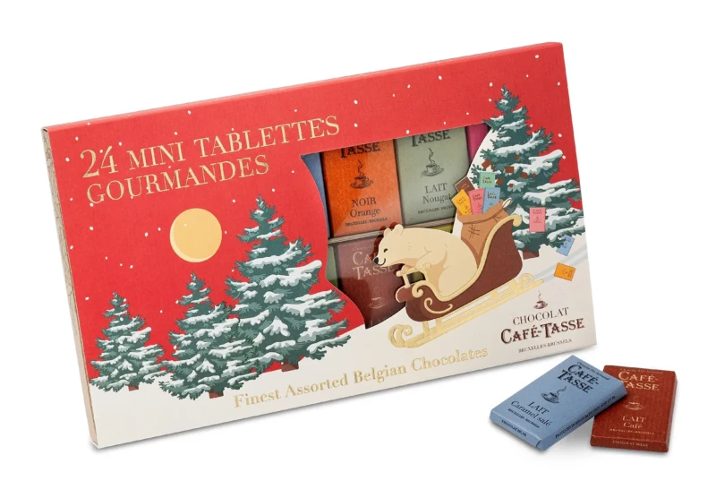 Boîte de Noël rouge illustrée de sapins enneigés et d'un ours polaire tirant un traîneau, « 24 Mini Tablettes Gourmandes » Café-Tassé, mini tablettes visibles noir orange et lait nougat.