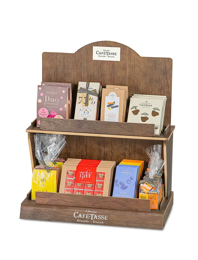 Présentoir en bois foncé à dossier arrondi, plaque « Chocolat Café-Tassé Bruxelles-Brussels », garni de coffrets variés : « Duo Gourmand », tablette « 77% » et « Zestes d'Orange ».